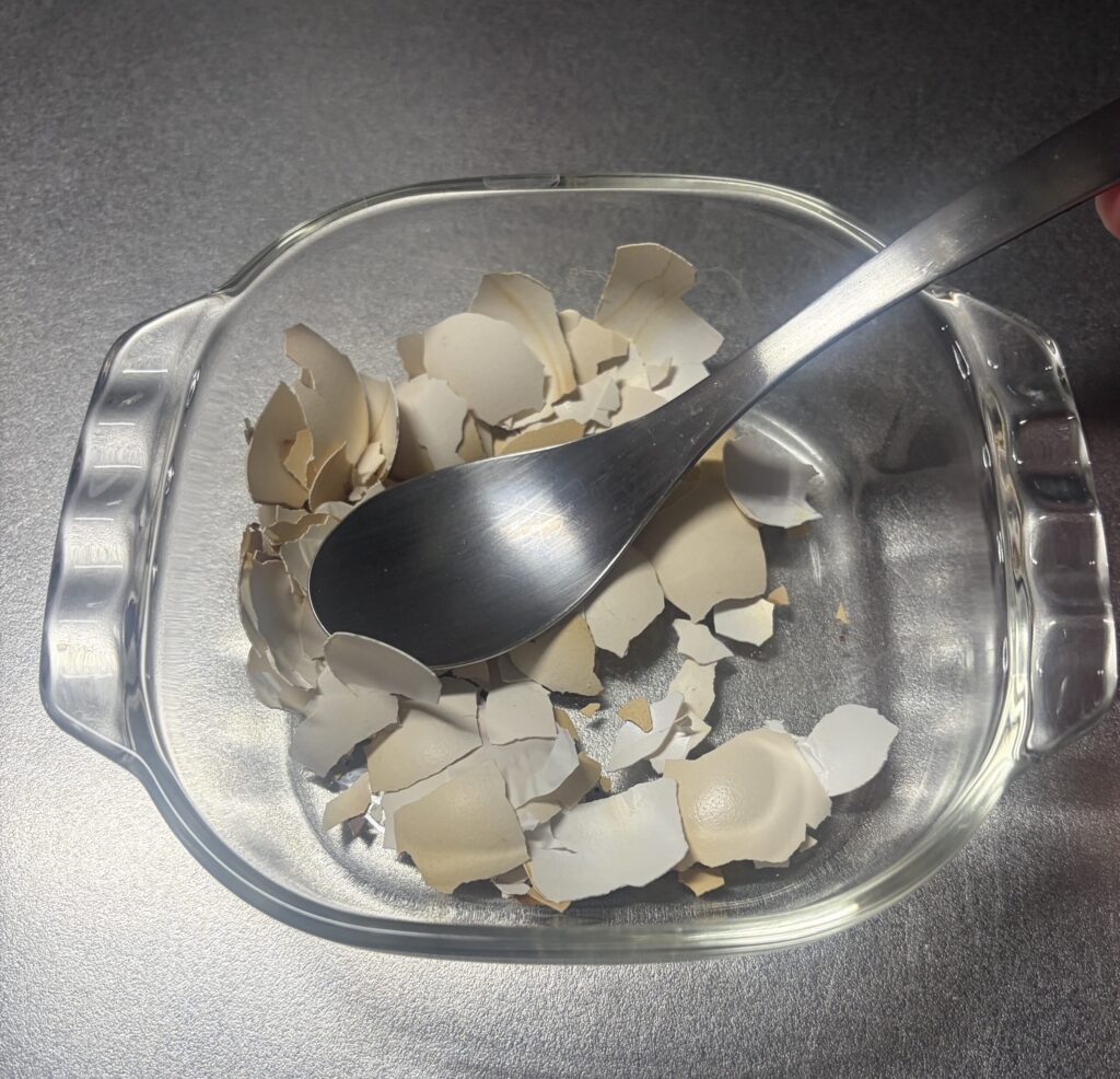 スプーンで卵の殻を砕いている途中